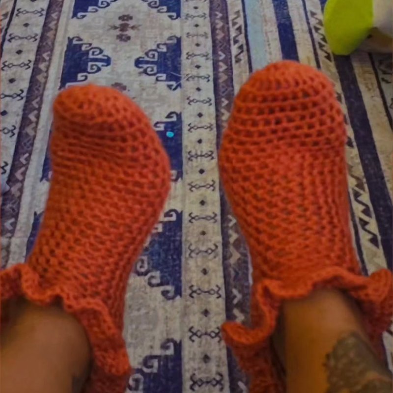 Orange crocheted slipper socks with ruffled trim